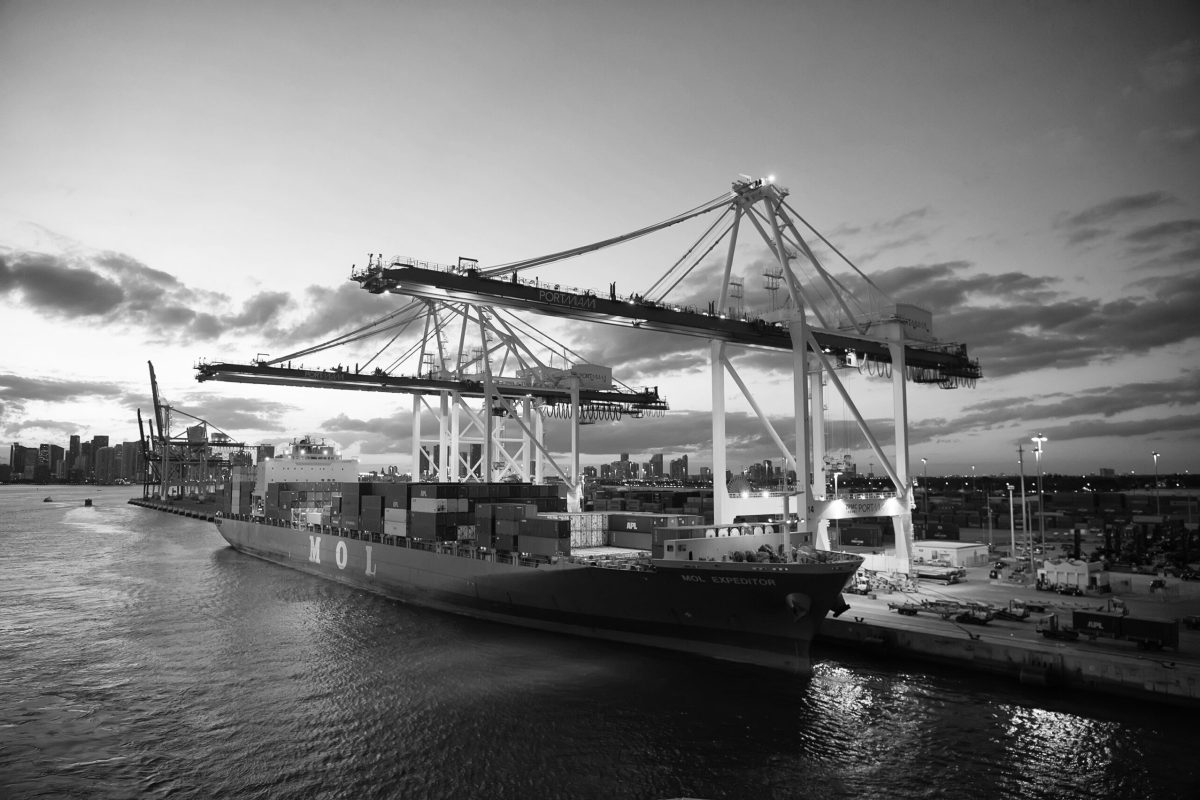 Miami, USA - March 01, 2016: freight boat MOL Expeditor in cargo port. Container ship and cranes illuminated in evening. Sea and coastal freight water transport. Shipment and transportation.